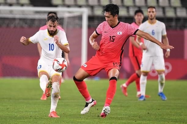Romania's midfielder Andrei Ciobanu fights for the ball with South Korea's midfielder Won Du-jae during the Tokyo 2020 Olympic Games men's group B...