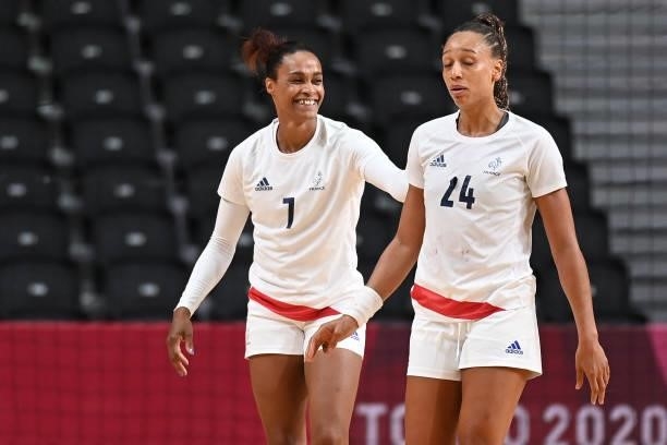 France's left wing Allison Pineau and France's pivot Beatrice Edwige react during the women's preliminary round group B handball match between...