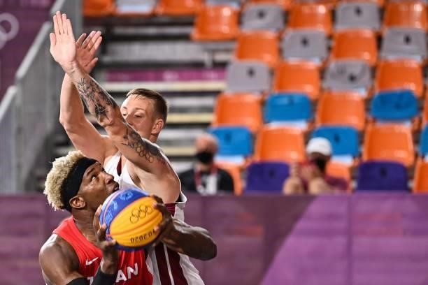 Japan's Ira Brown fights for the ball with Latvia's Karlis Lasmanis during the men's first round 3x3 basketball match between Latvia and Japan at the...