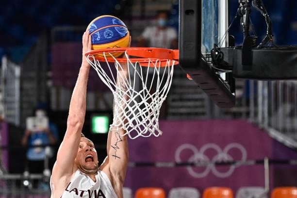 Latvia's Karlis Lasmanis scores a basket during the men's first round 3x3 basketball match between Latvia and Japan at the Aomi Urban Sports Park in...
