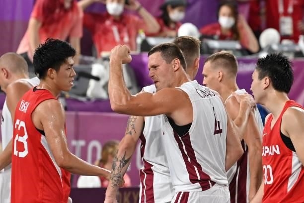 Latvia's Agnis Cavars celebrates with teammates after wining at the end of the men's first round 3x3 basketball match between Latvia and Japan at the...