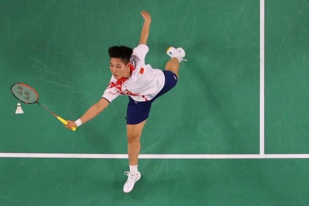 China's Huang Dongping hits a shot in her mixed doubles badminton group stage match with China's Wang Yilyu against Hong Kong's Tang Chun Man and...