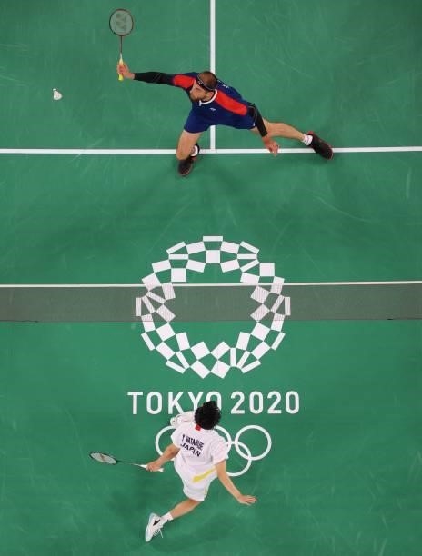 Russia's Vladimir Ivanov hits a shot in his men's doubles badminton group stage match with Russia's Ivan Sozonov against Japan's Yuta Watanabe and...