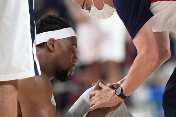 France's Guerschon Yabusele checks his knee next to the team's doctor during the men's preliminary round group A basketball match between France and...