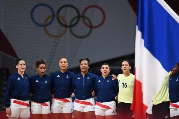 France's centre back Alexandra Lacrabere and teammates sing the national anthem before the women's preliminary round group B handball match between...