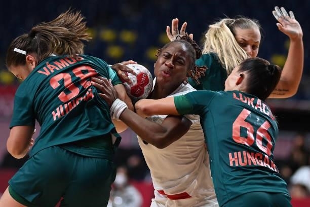 France's left wing Coralie Lassource is challenged during the women's preliminary round group B handball match between Hungary and France of the...