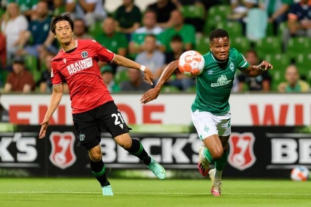 Sei Muroya of Hannover 96 and Felix Agu of SV Werder Bremen battle for the ball during the Second Bundesliga match between SV Werder Bremen and...