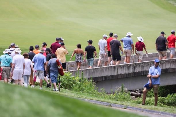 Fans walk across a bridge on the 9th hole during the final round of the Price Cutter Charity Championship presented by Dr. Pepper at Highland Spring...