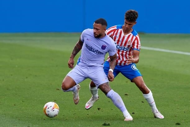 Memphis Depay of Barcelona and Ilyas Saira of Girona compete for the ball during the pre-season friendly match between FC Barcelona and Girona FC at...