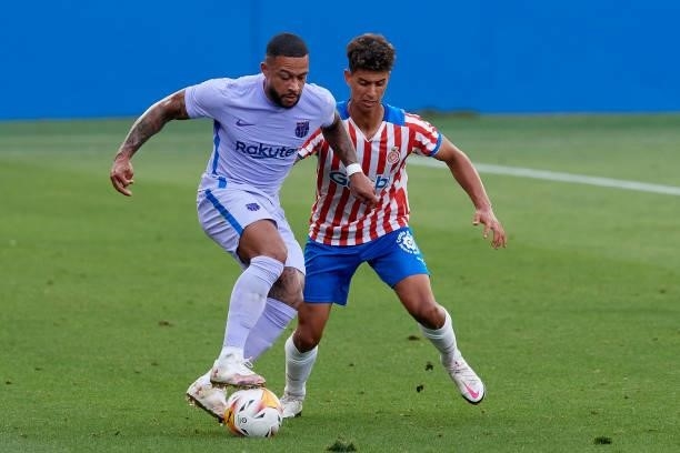 Memphis Depay of Barcelona and Ilyas Saira of Girona compete for the ball during the pre-season friendly match between FC Barcelona and Girona FC at...