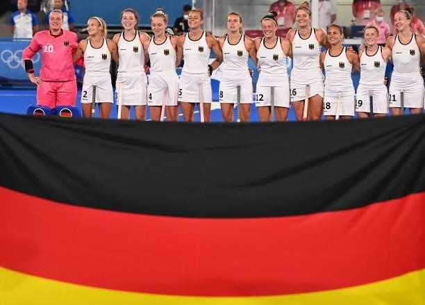 Players of Germany listen to their national anthem before the women's pool A match of the Tokyo 2020 Olympic Games field hockey competition against...
