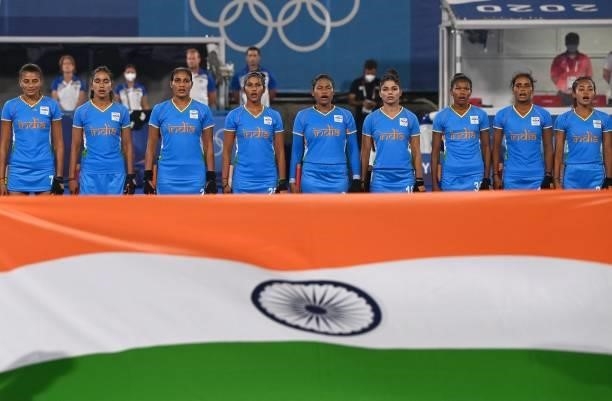 Players of India listen to their national anthem before the women's pool A match of the Tokyo 2020 Olympic Games field hockey competition against...