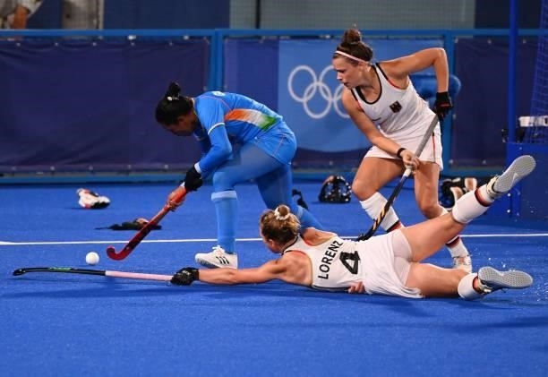 India's Deep Grace Ekka is marked by Germany's Nike Lorenz and Kira Horn during their women's pool A match of the Tokyo 2020 Olympic Games field...