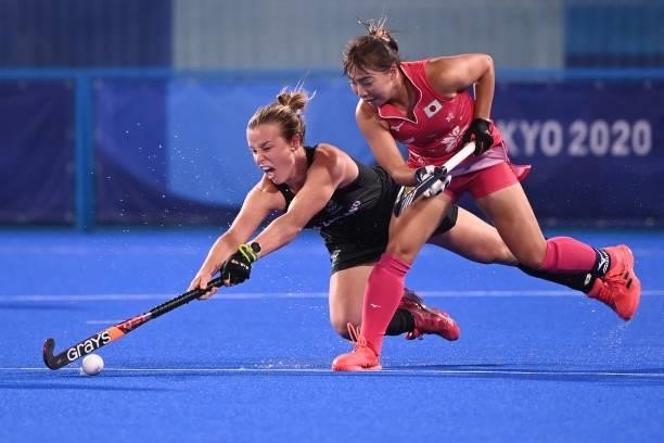 New Zealand's Megan Hull and Japan's Yukari Mano vie for the ball during their women's pool B match of the Tokyo 2020 Olympic Games field hockey...