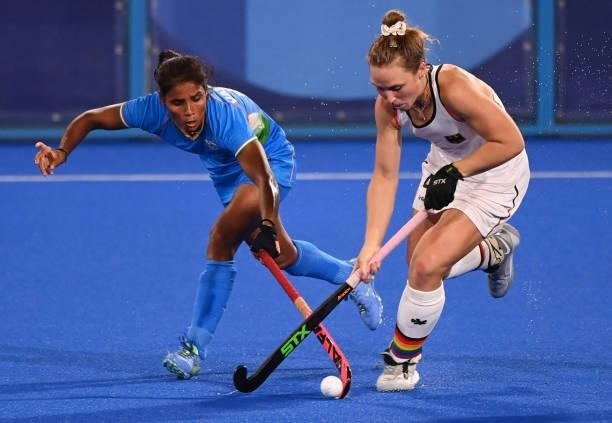 Germany's Nike Lorenz is tackled by India's Vandana Katariya during their women's pool A match of the Tokyo 2020 Olympic Games field hockey...
