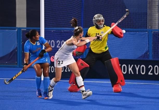 Germany's Cecile Pieper tries to score past India's goalkeeper Savita as India's Gurjit Kaur looks on during their women's pool A match of the Tokyo...