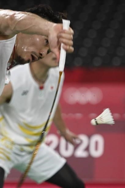 Japan's Keigo Sonoda hits a shot next to Japan's Takeshi Kamura in their men's doubles badminton group stage match against China's Liu Yuchen and...