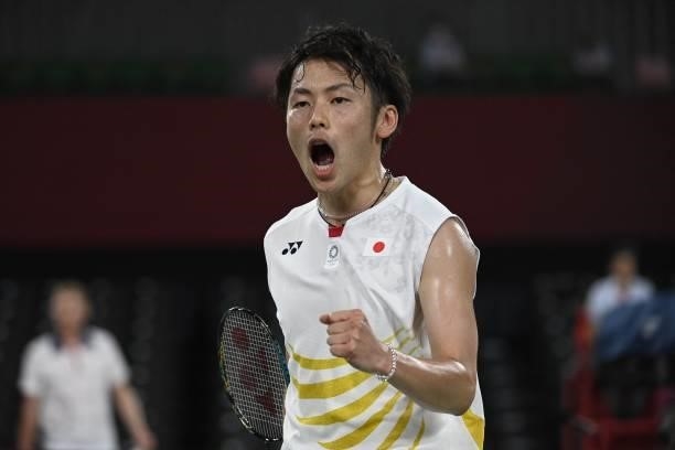 Japan's Takeshi Kamura reacts after a point in his men's doubles badminton group stage match with Japan's Keigo Sonoda against China's Liu Yuchen and...