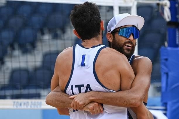Italy's Daniele Lupo hugs partner Paolo Nicolai in their men's preliminary beach volleyball pool F match between Japan and Italy during the Tokyo...