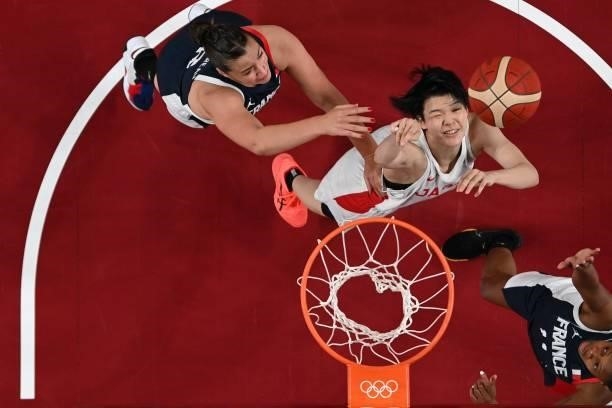 Japan's Himawari Akaho shoots the ball as France's Valeriane Vukosavljevic and Alexia Chartereau try to block in the women's preliminary round group...