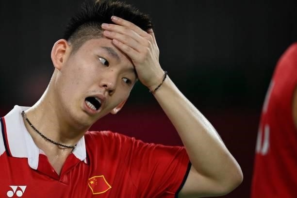 China's Liu Yuchen reacts next to China's Li Junhui in their men's doubles badminton group stage match against Japan's Keigo Sonoda and Japan's...