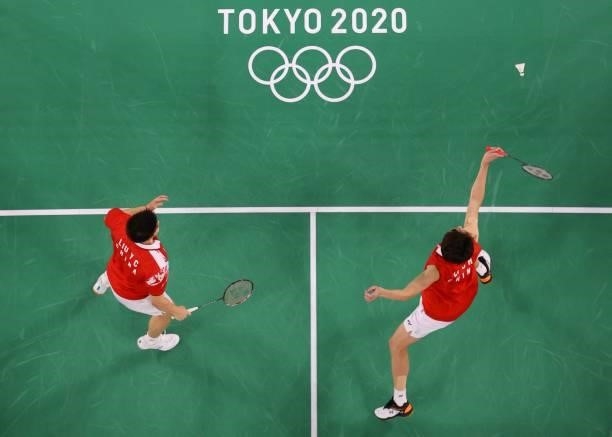 China's Li Junhui hits a shot next to China's Liu Yuchen in their men's doubles badminton group stage match against Japan's Keigo Sonoda and Japan's...