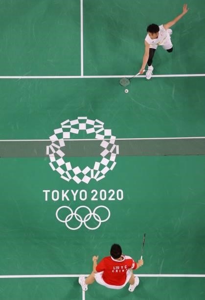 Japan's Takeshi Kamura hits a shot next to Japan's Keigo Sonoda in their men's doubles badminton group stage match against China's Liu Yuchen and...