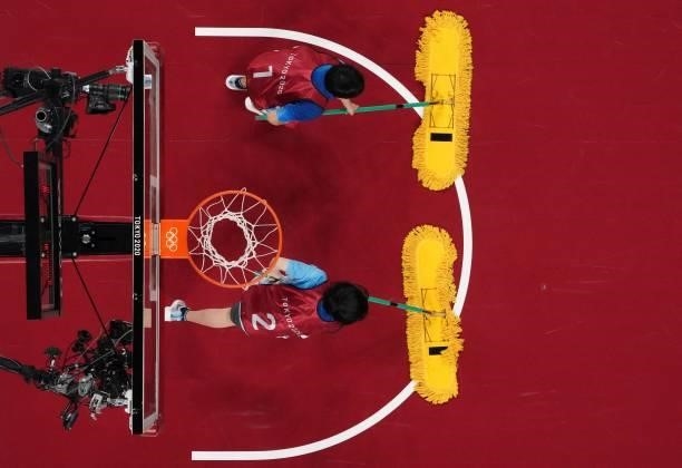 Volunteers clean the court during the women's preliminary round group B basketball match between France and Japan during the Tokyo 2020 Olympic Games...