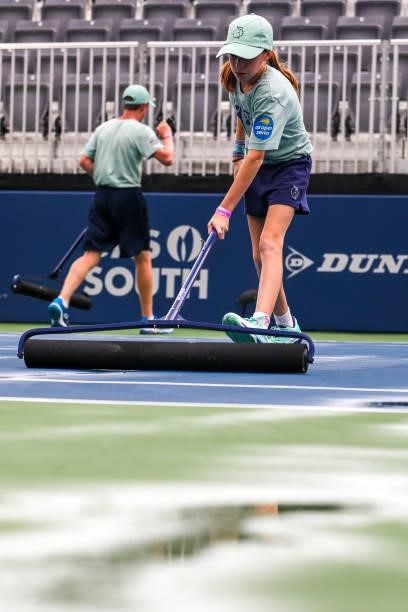 Tournament staff work to squeegee off the court following a rain delay at the Truist Atlanta Open at Atlantic Station on July 26, 2021 in Atlanta,...