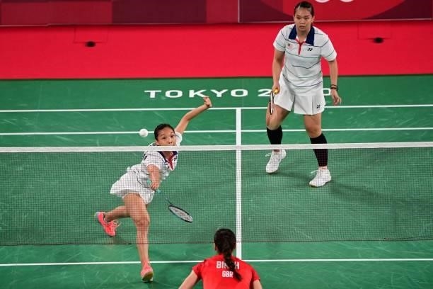 Malaysia's Chow Mei Kuan hits a shot next to Malaysia's Lee Meng Yean in their women's doubles badminton group stage match against Britain's Lauren...