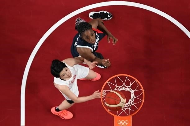 Japan's Himawari Akaho and France's Endene Miyem look at the basket in the women's preliminary round group B basketball match between France and...