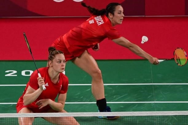 Britain's Chloe Birch hits a shot next to Britain's Lauren Smith in their women's doubles badminton group stage match against Malaysia's Lee Meng...