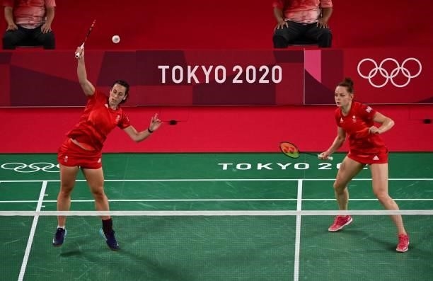Britain's Chloe Birch hits a shot next to Britain's Lauren Smith in their women's doubles badminton group stage match against Malaysia's Lee Meng...