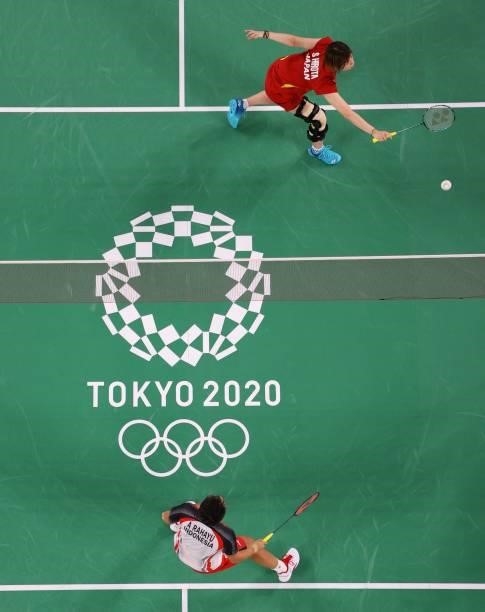 Japan's Sayaka Hirota , wearing a leg brace, hits a shot next to Japan's Yuki Fukushima in their women's doubles badminton group stage match against...