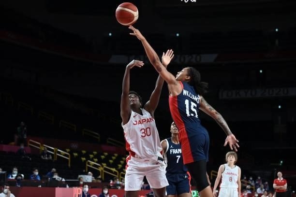 Japan's Evelyn Mawuli handles the ball as France's Gabrielle Williams tries to block in the women's preliminary round group B basketball match...
