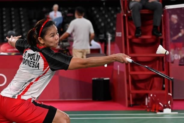 Indonesia's Greysia Polii hits a shot next to Indonesia's Apriyani Rahayu in their women's doubles badminton group stage match against Japan's Sayaka...