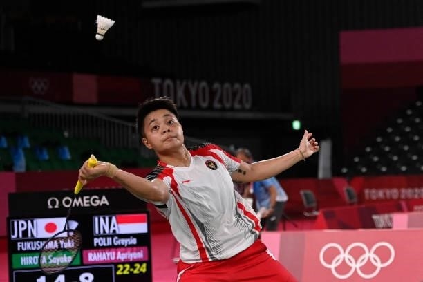 Indonesia's Apriyani Rahayu hits a shot next to Indonesia's Greysia Polii in their women's doubles badminton group stage match against Japan's Sayaka...