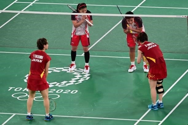 Indonesia's Apriyani Rahayu and Indonesia's Greysia Polii gesture after winning their women's doubles badminton group stage match against Japan's...