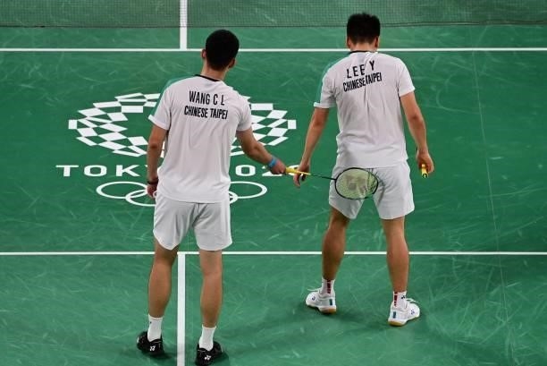 Taiwan's Wang Chi-lin gestures to partner Taiwan's Lee Yang in their men's doubles badminton group stage match against Indonesia's Marcus Fernaldi...