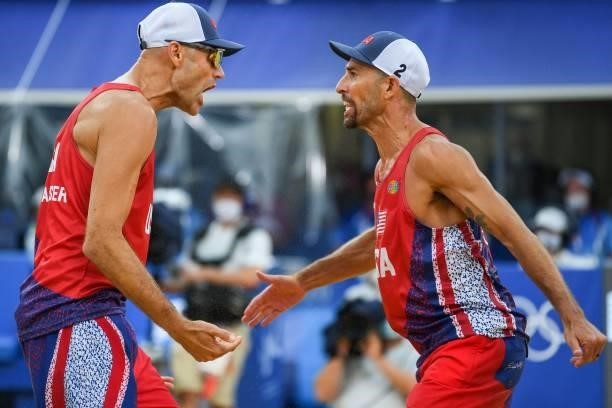 S Philip Dalhausser gestures to partner Nicholas Lucena in their men's preliminary beach volleyball pool D match between Brazil and the USA during...