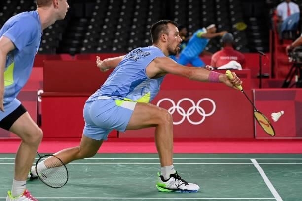 Denmark's Anders Skaarup Rasmussen hits a shot next to Denmark's Kim Astrup in their men's doubles badminton group stage match against Japan's Yuta...