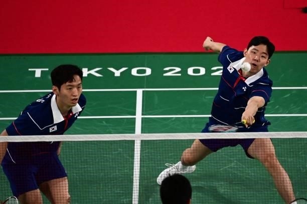 South Korea's Choi Sol-gyu looks on as South Korea's Seo Seung-jae hits a shot in their men's doubles badminton group stage match against Indonesia's...
