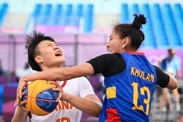 China's Wan Jiyuan fights for the ball with Mongolia's Khulan Onolbaatar during the women's pool round 3x3 basketball match between China and...
