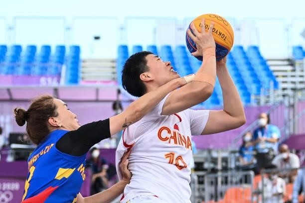 Mongolia's Chimeddolgor Enkhtaivan fights for the ball with China's Zhang Zhiting during the women's pool round 3x3 basketball match between China...