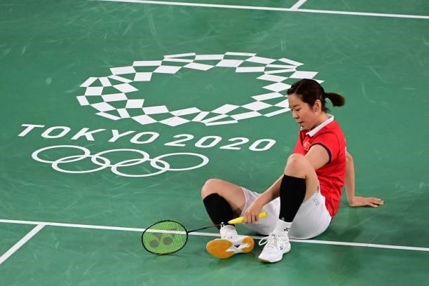 China's Jia Yifan gets up from the court in her women's doubles badminton group stage match with China's Chen Qingchen against South Korea's Kim...