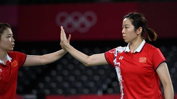 China's Jia Yifan and China's Chen Qingchen react between points in their women's doubles badminton group stage match against South Korea's Kim...