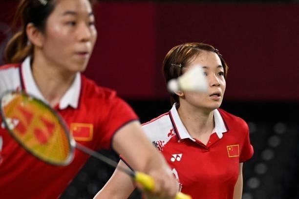 China's Chen Qingchen looks on as China's Jia Yifan hits a shot in their women's doubles badminton group stage match against South Korea's Kim...