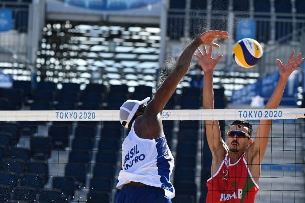 Morocco's Zouheir Elgraoui tries to block a shot from Brazil's Evandro Goncalves Oliveira Junior during their men's preliminary beach volleyball pool...