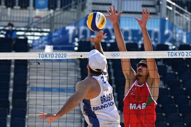Morocco's Zouheir Elgraoui tries to block a shot from Brazil's Bruno Oscar Schmidt during their men's preliminary beach volleyball pool E match...