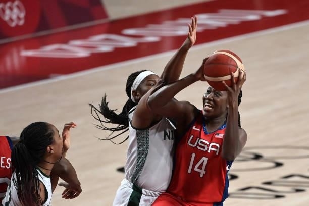 S Tina Charles handles the ball as Nigeria's Amy Okonkwo tries to block in the women's preliminary round group B basketball match between Nigeria and...